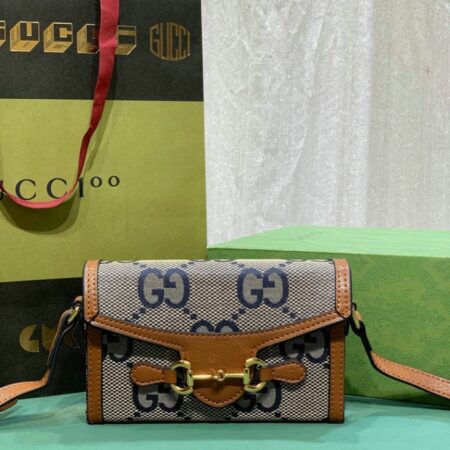 Stylish handbag with "GG" monogram, brown leather accents, and branded packaging with item code.