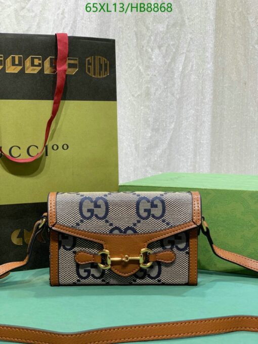 Stylish handbag with "GG" monogram, brown leather accents, and branded packaging with item code.